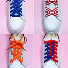 A close-up of a string shoelace threaded through and tied on a shoe.
