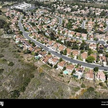 An aerial view of a town with built-up streets beside open undeveloped land.