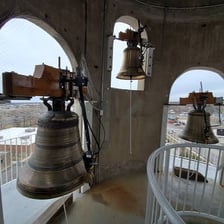 A church tower with a visible belfry and bell openings.