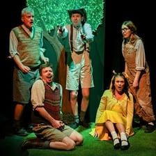 Actors performing a light-hearted scene on a theatre stage