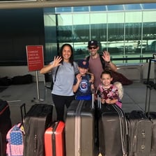 A traveller with luggage departing through an airport.