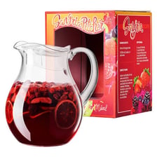 A glass pitcher of red sangria containing pieces of fruit.