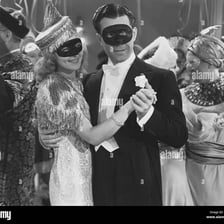 People wearing costumes at a fancy-dress ball.
