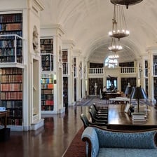 A historic athenaeum interior with bookshelves and a reading room.