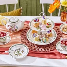 A British tea meal with teapot, cups and sandwiches.