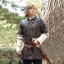 A historical leather jerkin jacket displayed on a mannequin