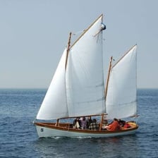A small ketch sailing on the water