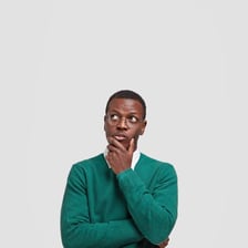 A person sitting thoughtfully while considering a problem.