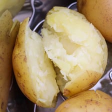 Potatoes shown in and beside a cooking pot