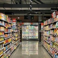 A supermarket aisle between stocked shelves