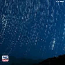 Several meteors streaking across a dark night sky.