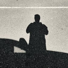 A person’s shadow extending across pavement