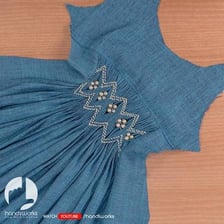 Close-up of decorative smocking embroidery on a garment.
