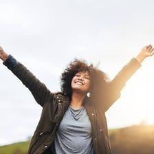A cheerful person enjoying a carefree moment outdoors.