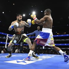 Two boxers competing in a boxing ring