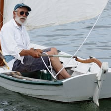 A tiller handle being used to steer a small boat.