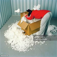 A person searching through the contents of a box.