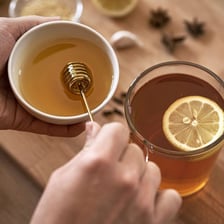 Honey being added to a drink to make it sweeter.