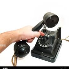 A person ending a telephone call by replacing the receiver.