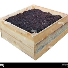 A wooden crate filled with soil