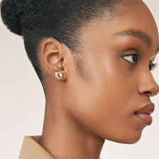 A close-up of an earlobe wearing an earring.