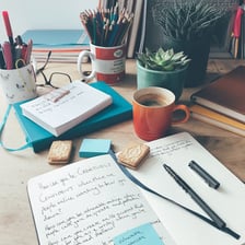 A poet writing creatively in a notebook.
