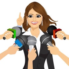 A person answering questions from reporters with microphones