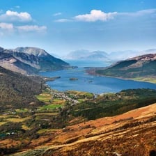A green Scottish Highland valley surrounded by mountains.