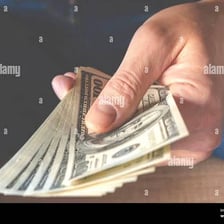 A hand discreetly taking banknotes, illustrating the informal sense of trousered.