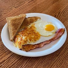A single egg served as part of a breakfast.