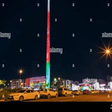 The flag of Oman displayed against a Muscat skyline.