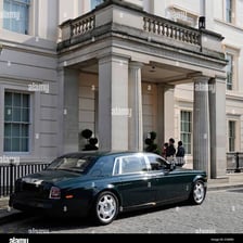 A long luxury limousine parked outside a hotel.