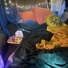 A camper inside a tent at a campsite.