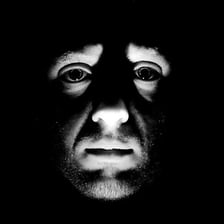 A person moving discreetly through shadows to avoid notice