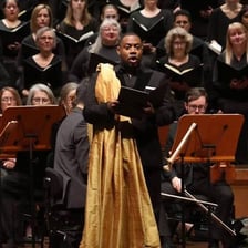 A countertenor singer performing on a concert stage