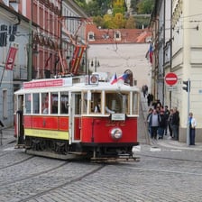 A tram travelling along railway tracks in a street