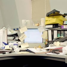 A disorderly desk illustrating a careless or sloppy state.