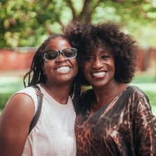 Two close friends smiling together.
