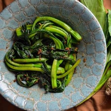 Vegetables being cooked as a Chinese-style stir-fry in a wok