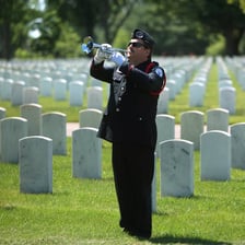 A military bugler performing at a memorial ceremony.