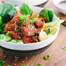A Hawaiian poke bowl containing cubed raw tuna, rice, and assorted toppings.
