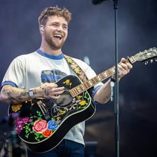 Singer Alex Warren performing at a concert.