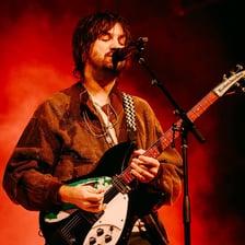 Tame Impala performing at a live concert.