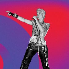 Billy Idol performing as a rock singer on stage.