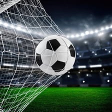 A soccer ball crossing into a goal net.