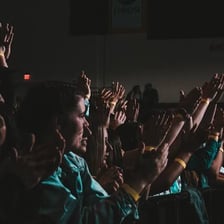 An audience applauding a performer in praise.