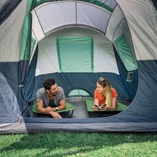 Portable folding camping cots set up inside a tent