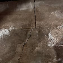 Water slowly passing through a crack in a surface.