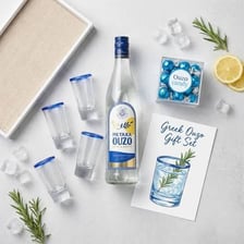A bottle of Greek ouzo beside a small serving glass.