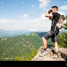 A person viewing a distant landscape through binoculars.
